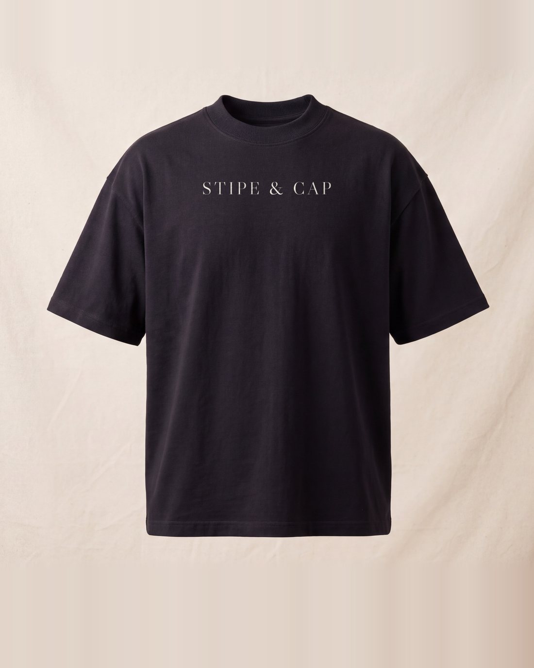 The near-black tee from the front: STIPE & CAP across the chest in raw cotton.